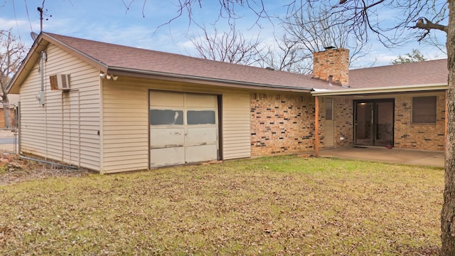 back of house with a patio, a yard, and a garage