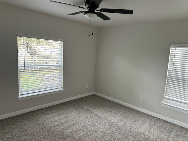 carpeted spare room featuring ceiling fan