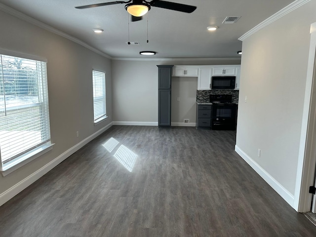 unfurnished living room featuring plenty of natural light, dark hardwood / wood-style flooring, and ornamental molding