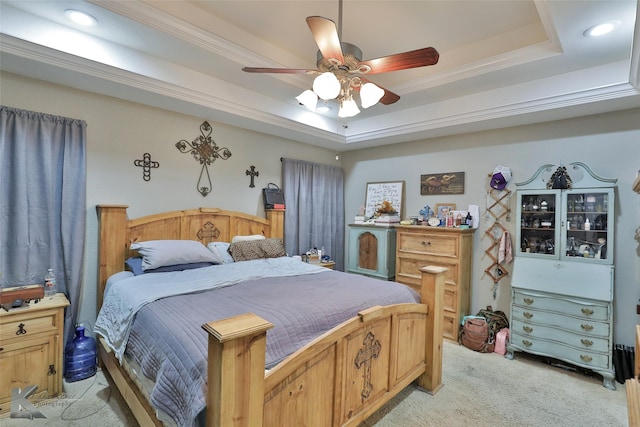 carpeted bedroom with ceiling fan, crown molding, and a raised ceiling