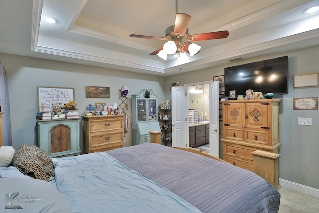 carpeted bedroom with ceiling fan, ensuite bath, crown molding, and a tray ceiling