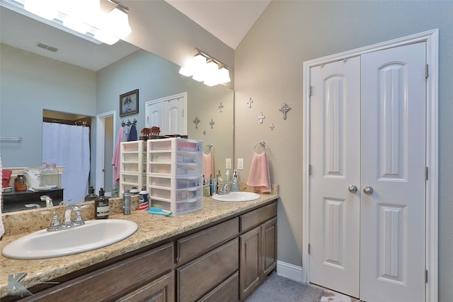 bathroom featuring lofted ceiling and vanity