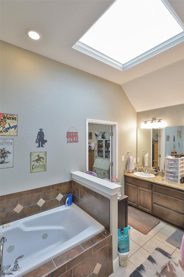 bathroom featuring tiled tub, tile patterned floors, vanity, and lofted ceiling