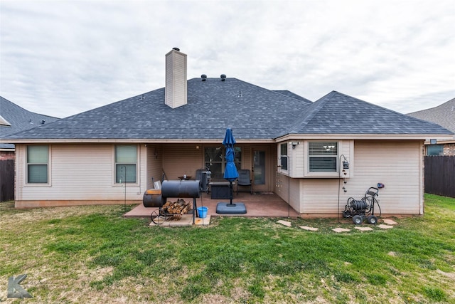 rear view of house featuring a patio area and a yard