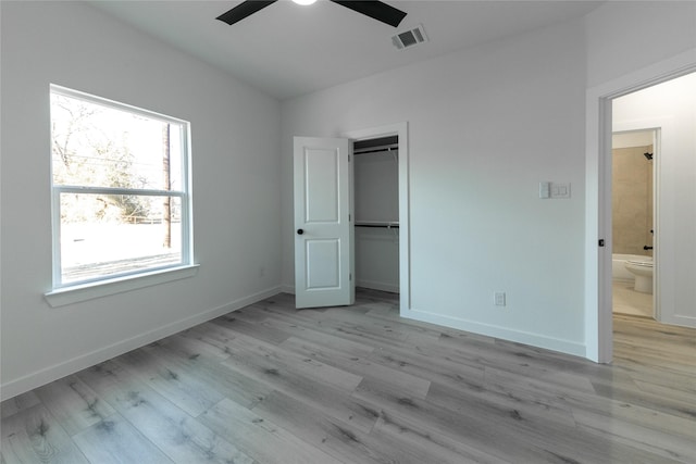 unfurnished bedroom with ceiling fan, light wood-type flooring, a closet, and connected bathroom