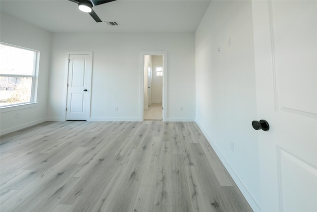 unfurnished bedroom featuring ceiling fan, ensuite bathroom, and light hardwood / wood-style flooring