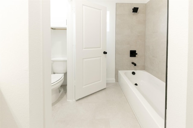 bathroom with toilet, tile patterned floors, and tiled shower / bath