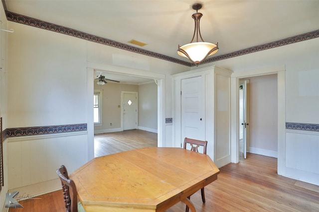 dining space with ceiling fan, ornamental molding, and light hardwood / wood-style flooring