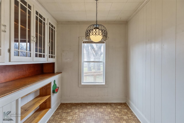 unfurnished dining area featuring crown molding