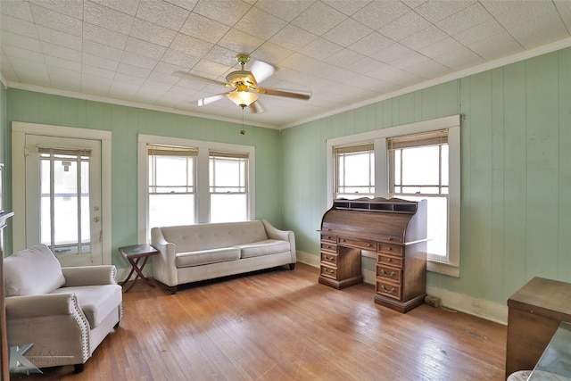 living room featuring light wood-type flooring, a wealth of natural light, and ornamental molding