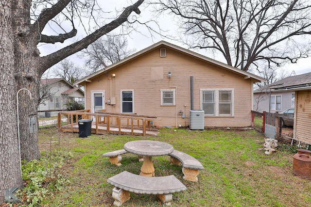 rear view of house featuring a deck, cooling unit, and a yard