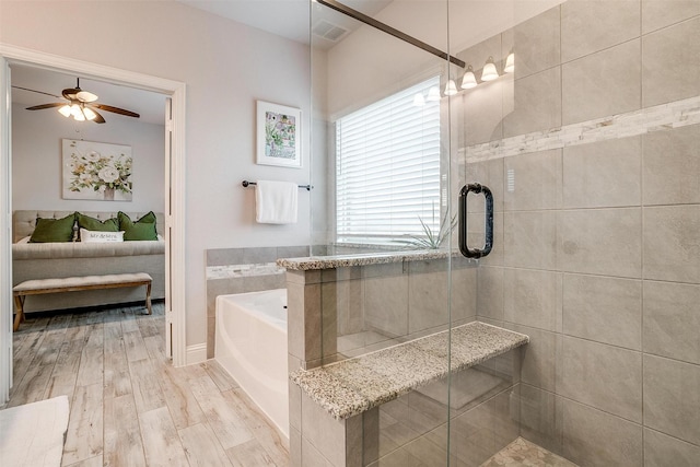 bathroom with wood finished floors, a ceiling fan, visible vents, a shower stall, and a bath