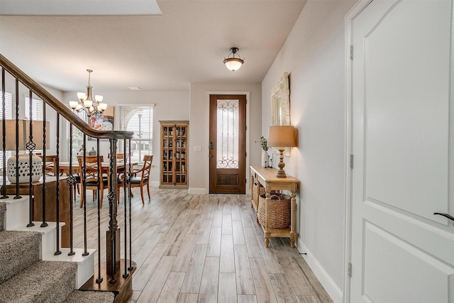 foyer with light hardwood / wood-style floors and a chandelier