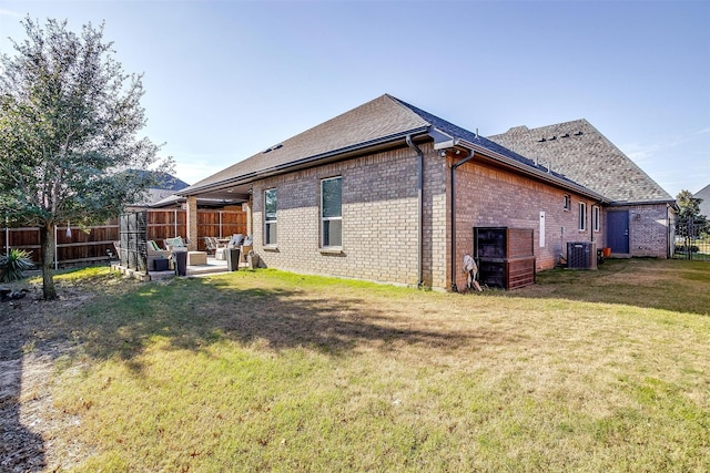 back of house with a lawn, central air condition unit, and a patio