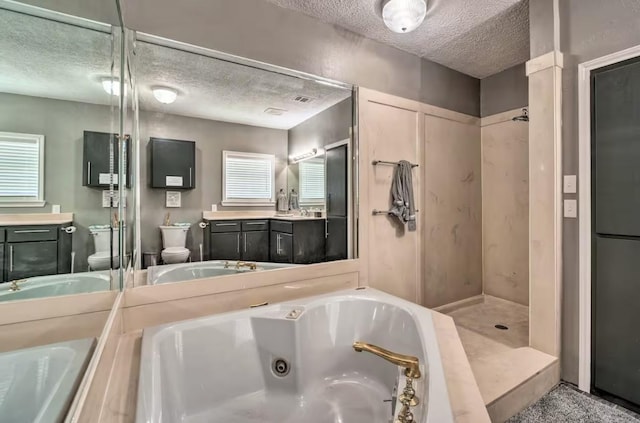 full bathroom featuring a textured ceiling, toilet, vanity, and separate shower and tub