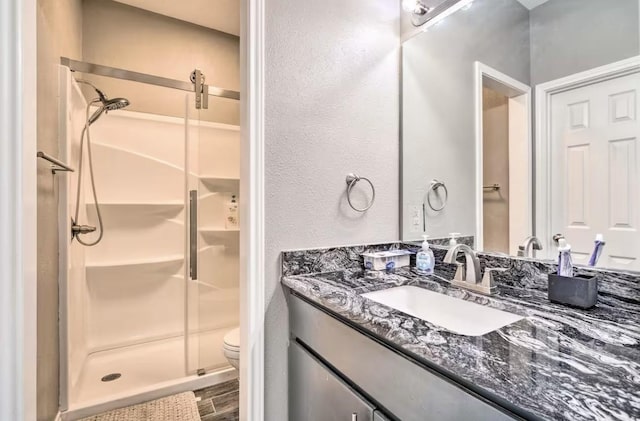 bathroom featuring vanity, toilet, and walk in shower