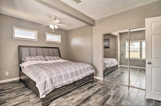 bedroom with ceiling fan, a closet, multiple windows, and a textured ceiling