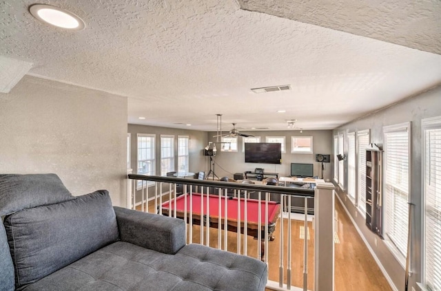 kitchen featuring wood-type flooring, a kitchen breakfast bar, and a textured ceiling