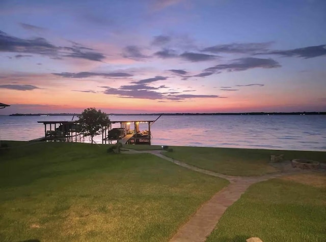 dock area with a water view and a yard