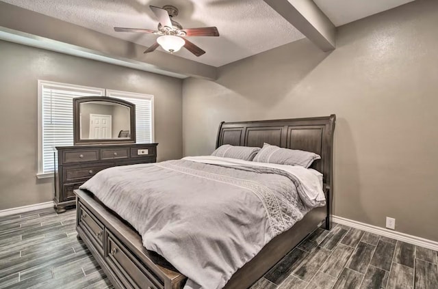 bedroom featuring ceiling fan, a textured ceiling, and beamed ceiling