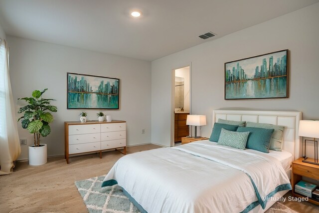 bedroom with light carpet and ensuite bath