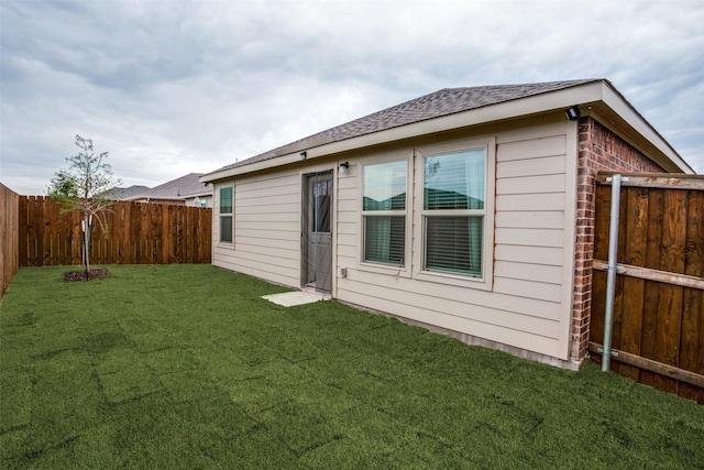 rear view of property featuring a lawn