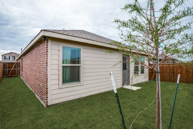 view of side of home with a yard