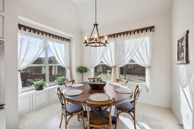 dining area featuring a chandelier and baseboards