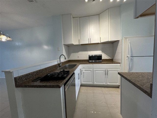 kitchen featuring appliances with stainless steel finishes, decorative light fixtures, white cabinetry, sink, and backsplash