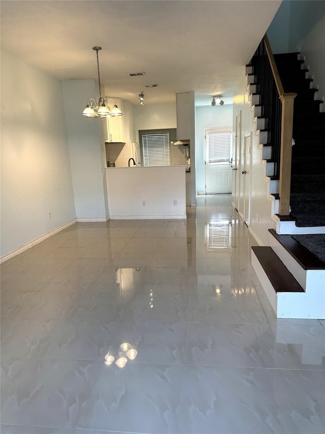 unfurnished living room featuring a notable chandelier