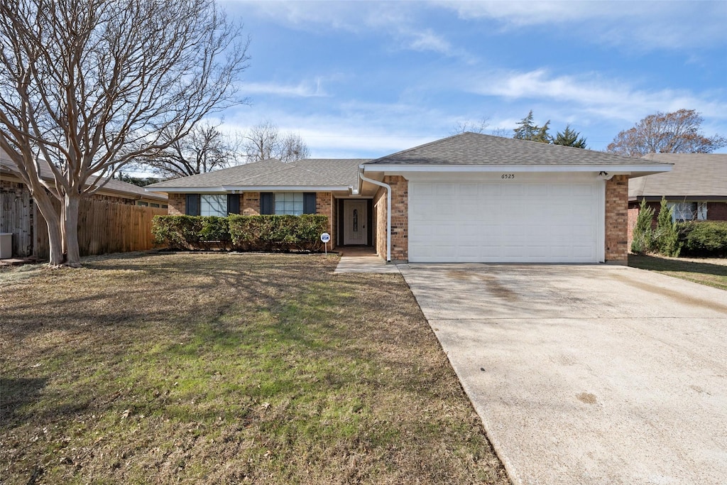 ranch-style house featuring a front lawn and a garage