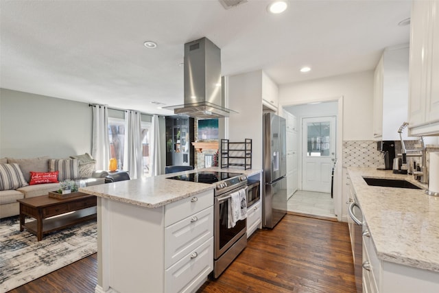 kitchen featuring light stone countertops, white cabinetry, decorative backsplash, island range hood, and stainless steel appliances