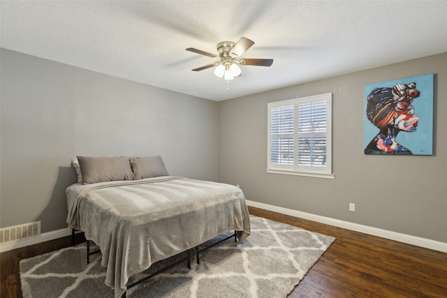 bedroom featuring ceiling fan, a textured ceiling, and dark hardwood / wood-style flooring