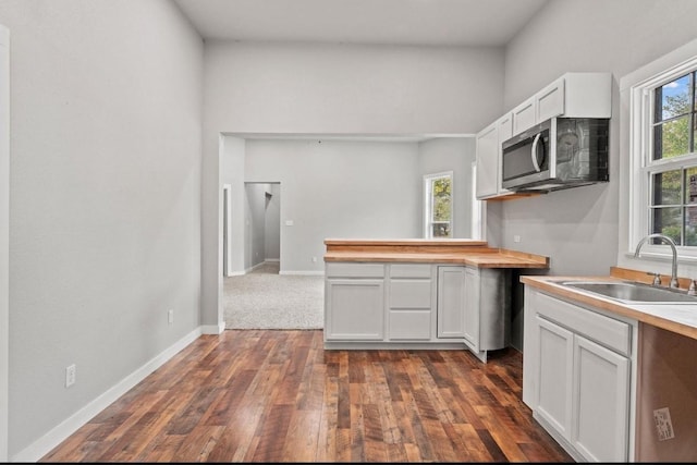 kitchen featuring sink, white cabinetry, dark hardwood / wood-style floors, and butcher block counters