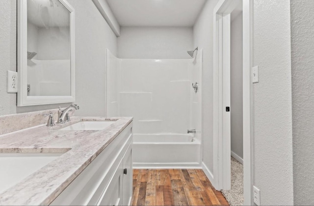 bathroom featuring wood-type flooring, vanity, and shower / bathing tub combination