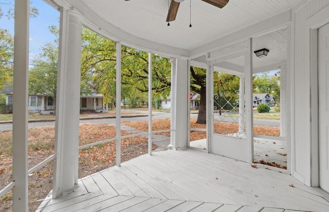 unfurnished sunroom with ceiling fan