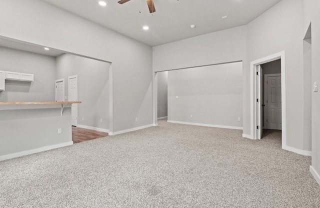 unfurnished living room with ceiling fan and carpet floors