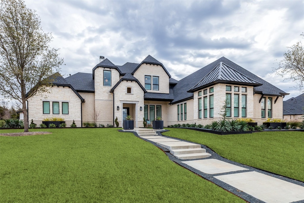 french country inspired facade featuring a front yard