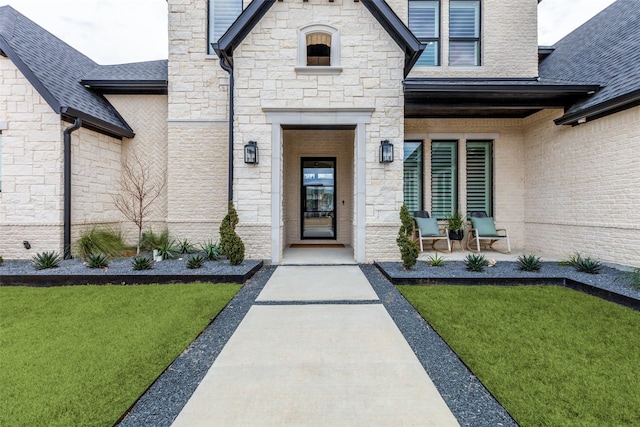 view of exterior entry with a lawn