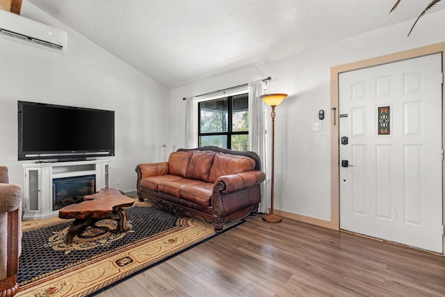 living room with hardwood / wood-style flooring, lofted ceiling, and a wall mounted AC