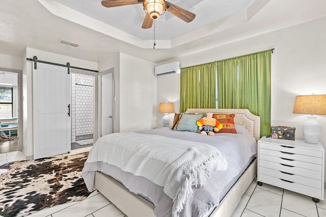 bedroom featuring ceiling fan, a barn door, a raised ceiling, and a wall mounted air conditioner