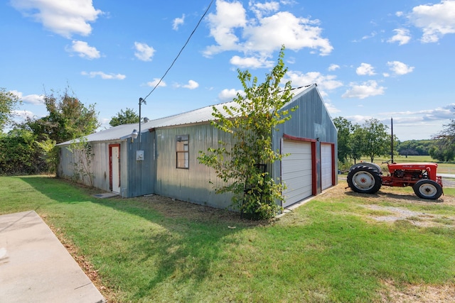 view of side of property with a garage, a yard, and an outbuilding