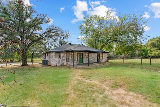 rear view of property with cooling unit and a lawn