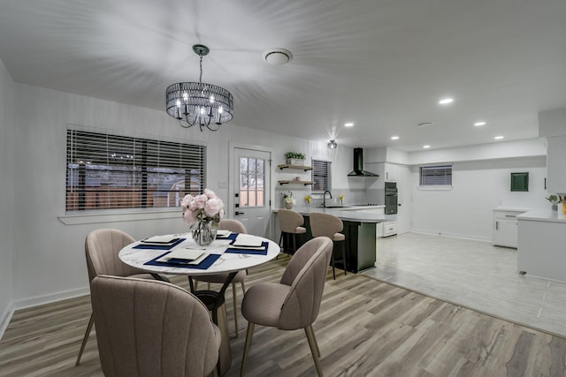 dining space with a chandelier, light hardwood / wood-style floors, and sink