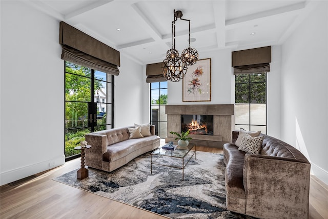 living room featuring beamed ceiling, a premium fireplace, coffered ceiling, and light hardwood / wood-style flooring