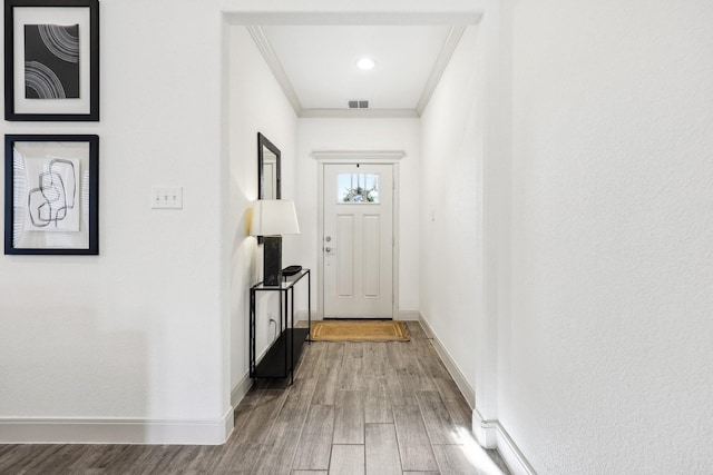 doorway with wood-type flooring and ornamental molding