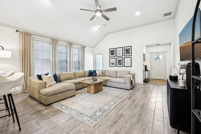 living room with lofted ceiling, ceiling fan, and ornamental molding