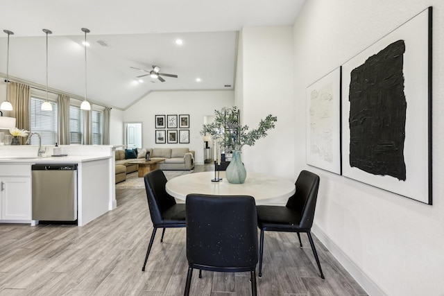 dining space with ceiling fan, vaulted ceiling, and sink