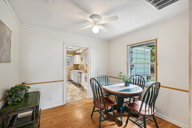 dining space featuring ceiling fan, light hardwood / wood-style flooring, and crown molding