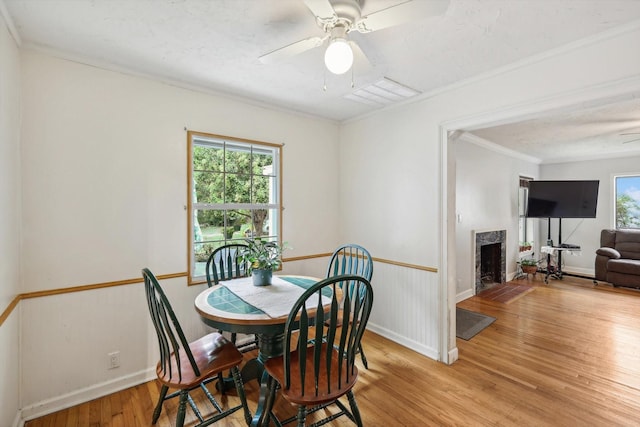 dining area featuring ceiling fan, wood-type flooring, and ornamental molding